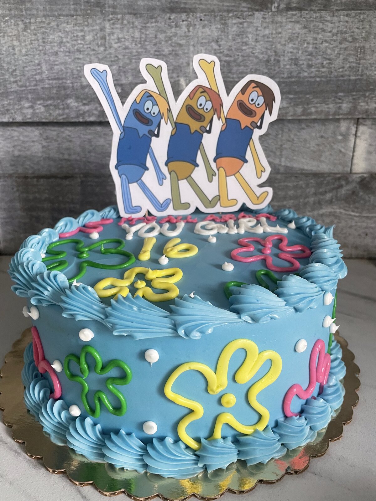 Blue birthday cake with cartoon characters at Lu's