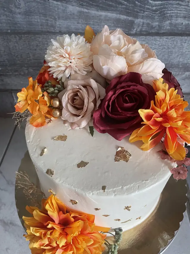 Elegant white floral cake with gold leaf at Lu's